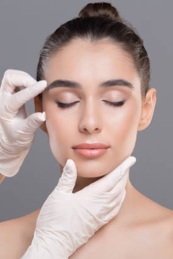 istockphoto-1161353643-612×612 Youth and beauty treatment. Cosmetologist examining facial wrinkles on young woman face